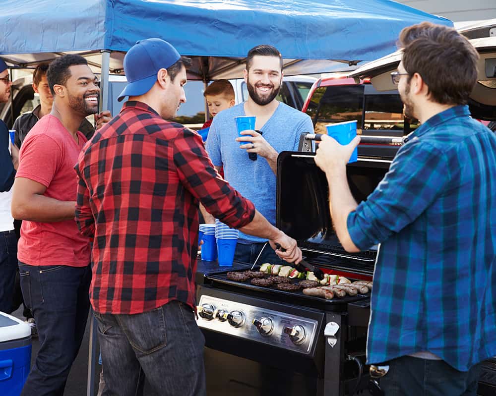 tailgating people in front of a grill