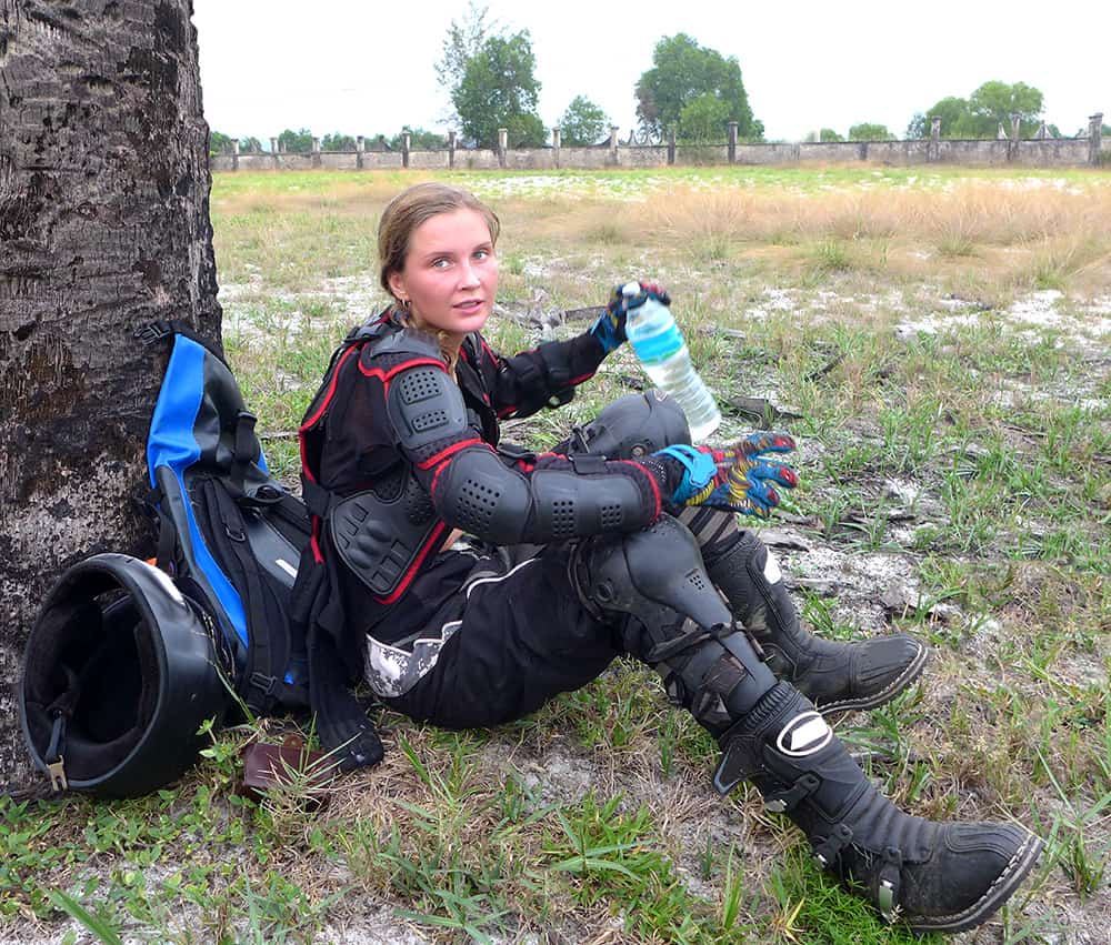 young enduro racer resting by a tree